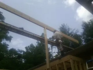 Carpenter setting a ridge beam over a new addition frame — Ice Dam Removal by Roofing Brothers in Blue Diamond
