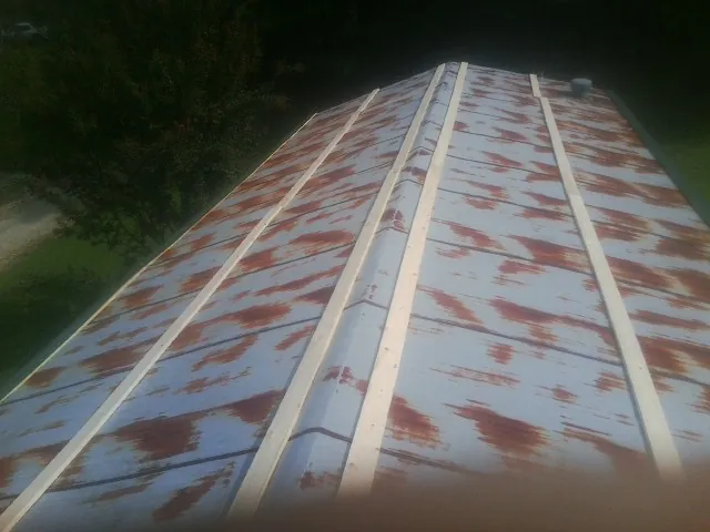 Rusted metal roof panels with new wood purlins before replacement — Storm Damage Roof Repair in Blue Diamond by Roofing Brothers