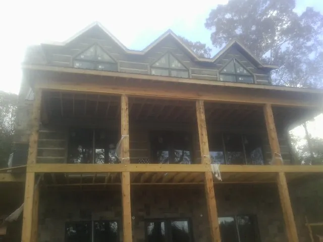 Dormers and porch framing on a large log home under construction — Roof Coating work by our crew in Blue Diamond