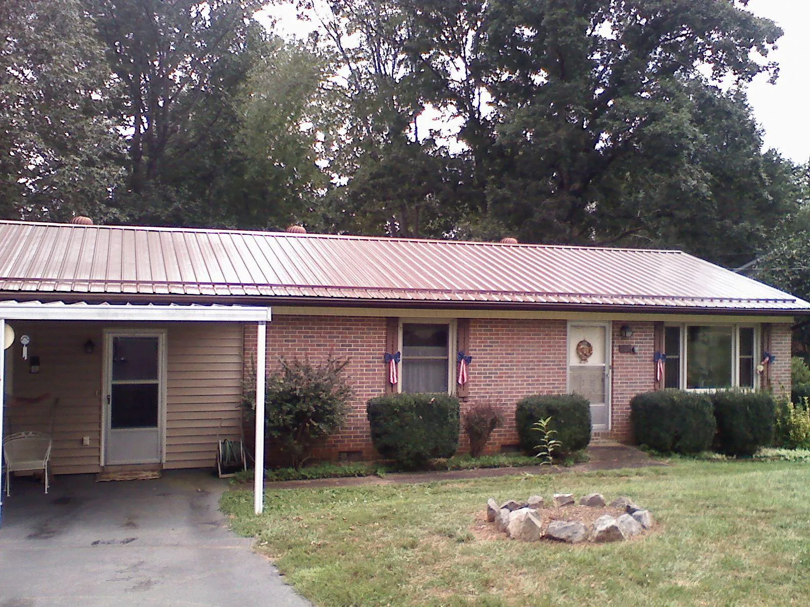 Bronze metal roof and carport on a brick ranch home — Roof Repair work by our crew in Blue Diamond