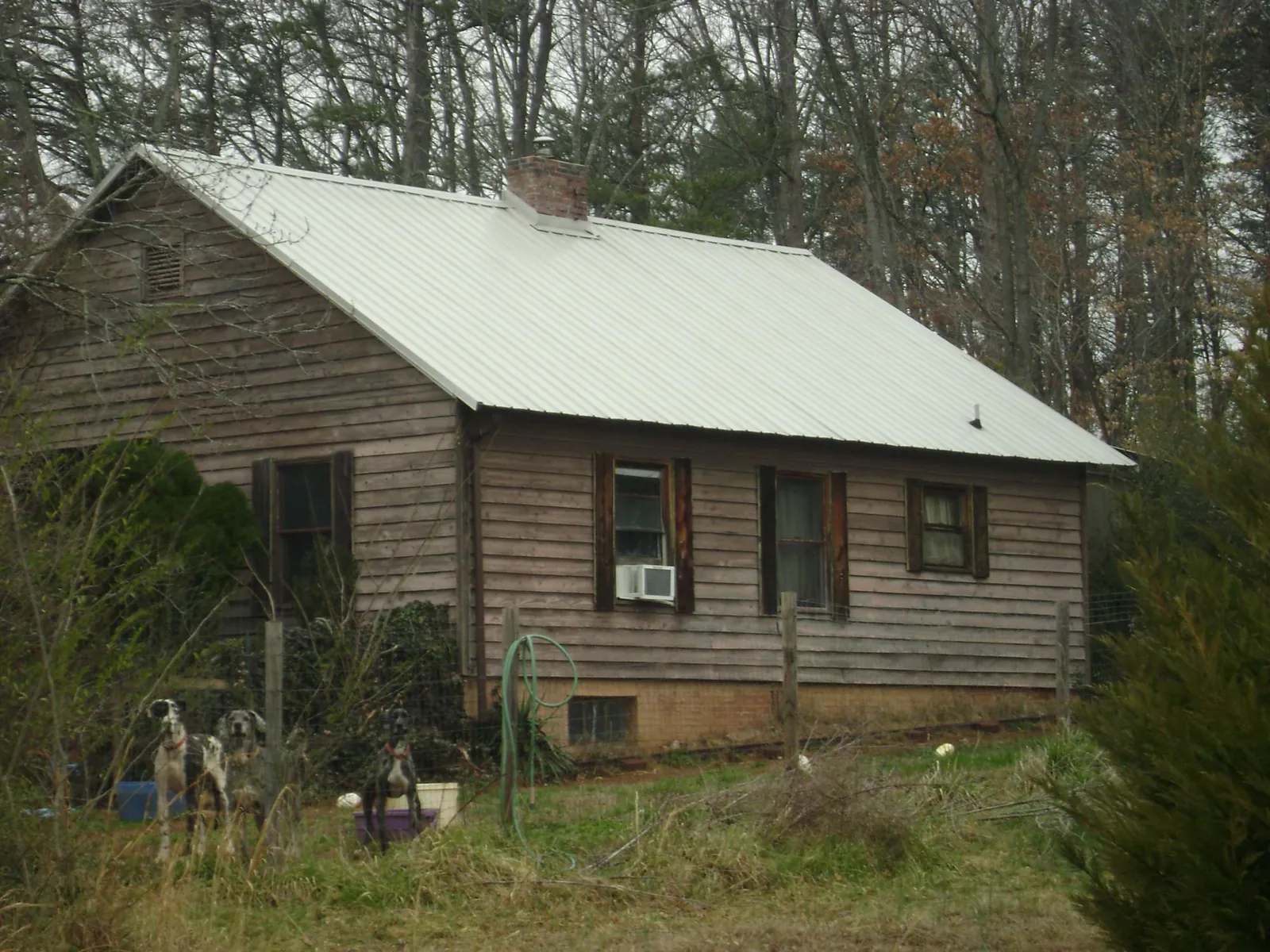 White metal roof on an old wood sided farmhouse, from a Metal Roof Installation job in Blue Diamond